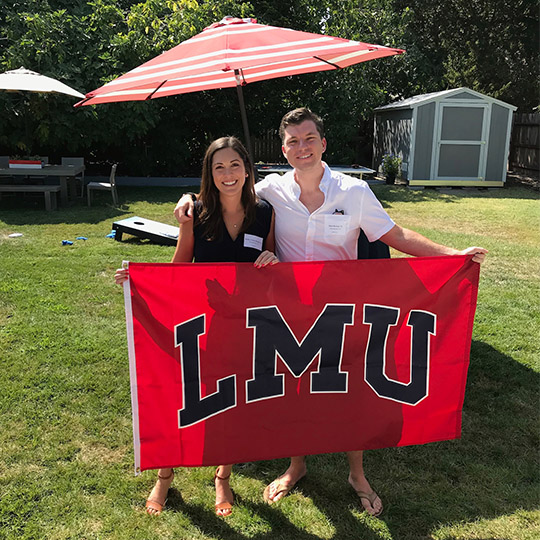 Couple smiling and holding an LMU flag